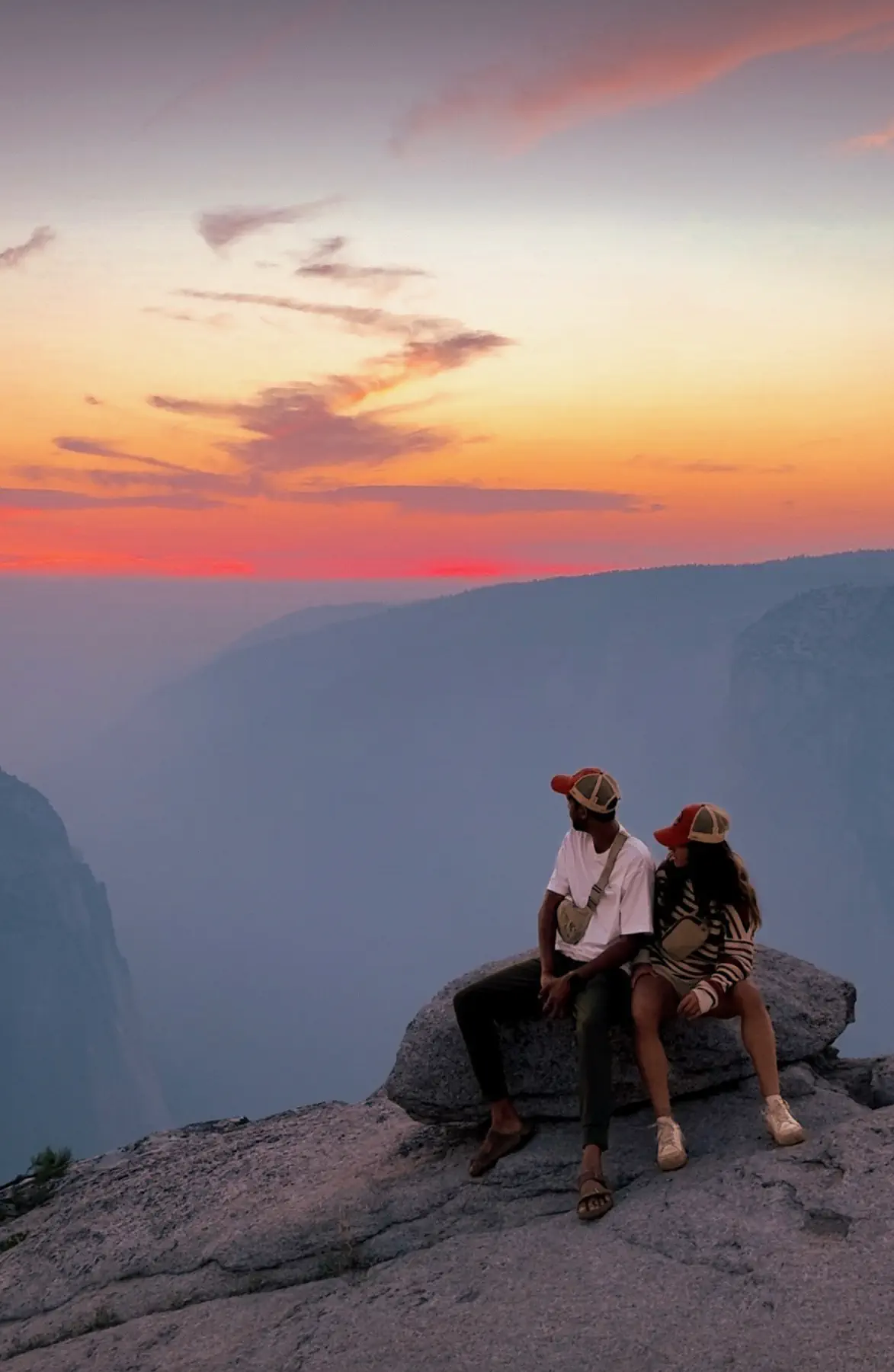 Naga and Lata sitting on a granite ledge above the valley at sunset