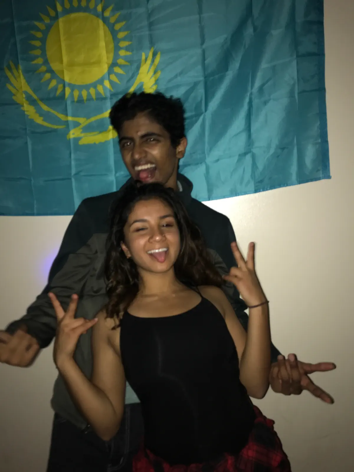 Naga and Lata pulling faces in front of a Kazakhstan flag