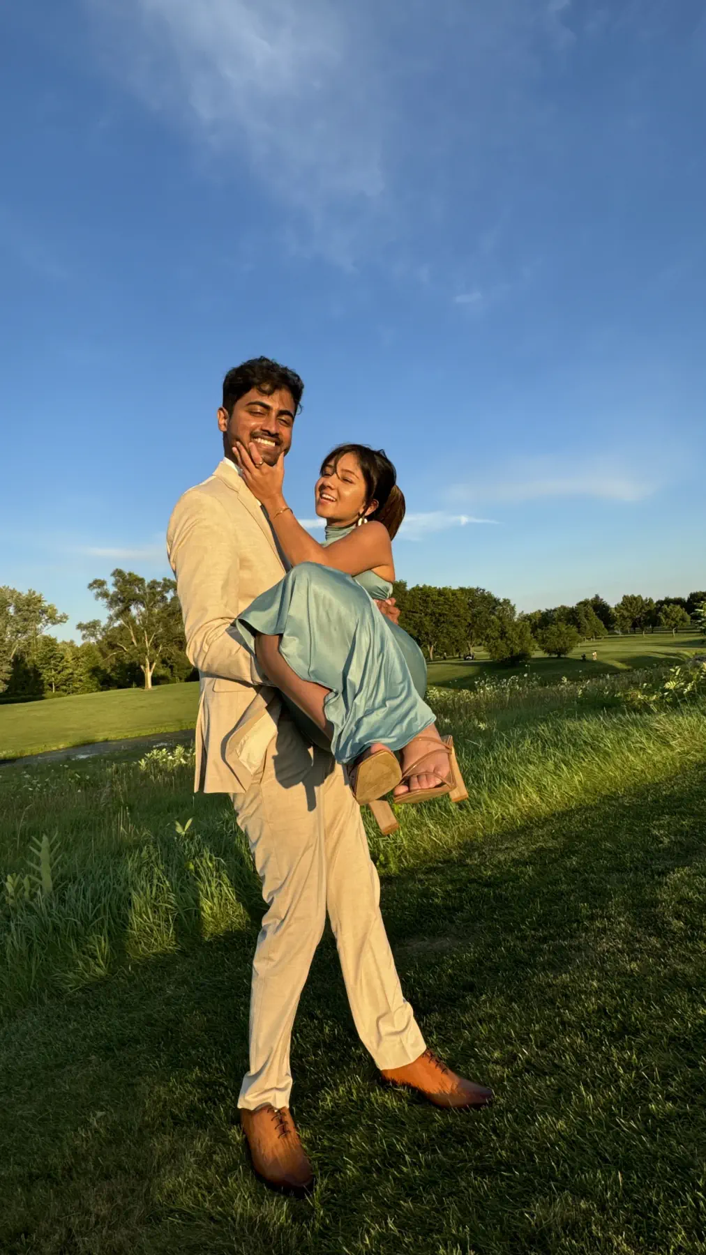 Naga carrying Lata across a sunlit lawn at golden hour