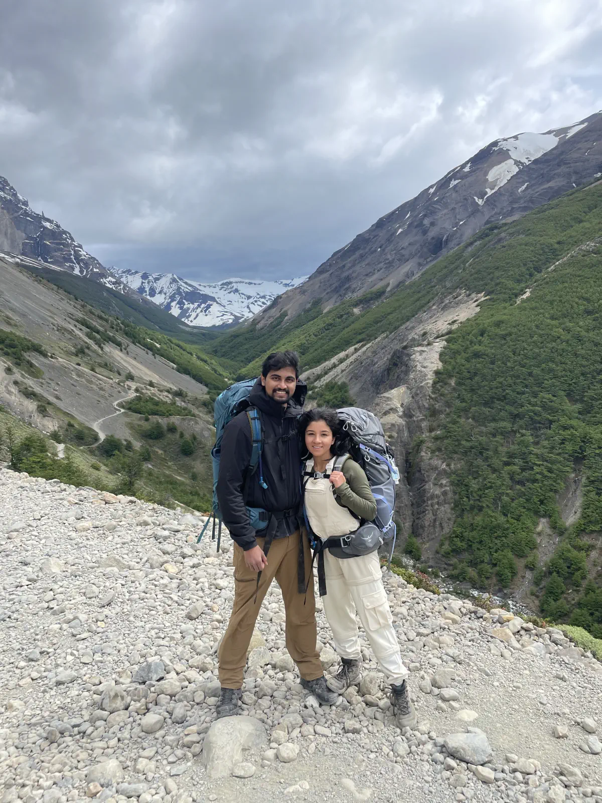Naga and Lata with hiking packs above a glacial mountain valley
