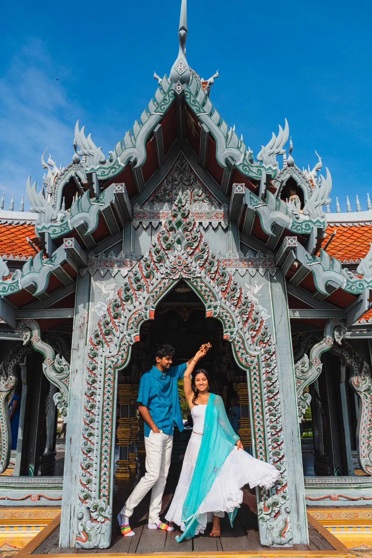 Naga twirling Lata in front of an ornate Thai temple