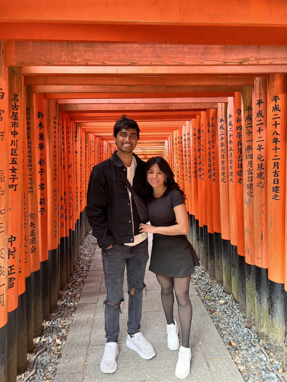 Naga and Lata standing in a tunnel of vermilion torii gates